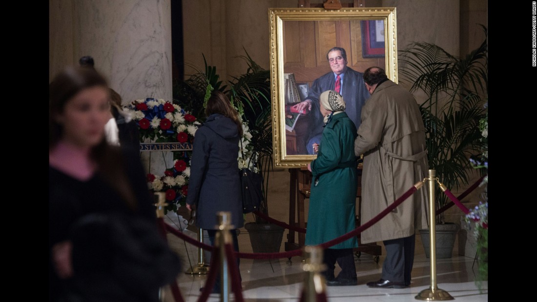 People look at a portrait of Scalia while paying their respects in Washington on February 19.