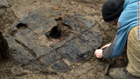 Archaeologists carefully uncover the 3,000-year-old wheel at England&#39;s Must Farm excavation site.