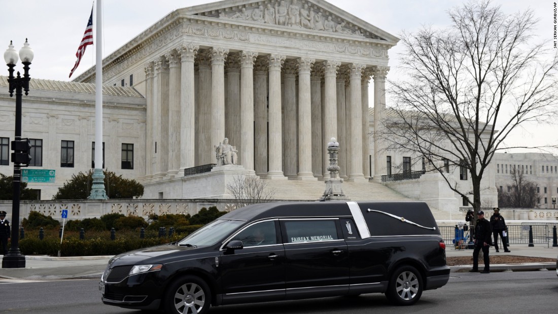 A hearse carrying the casket departs the U.S. Supreme Court Building on February 20. 