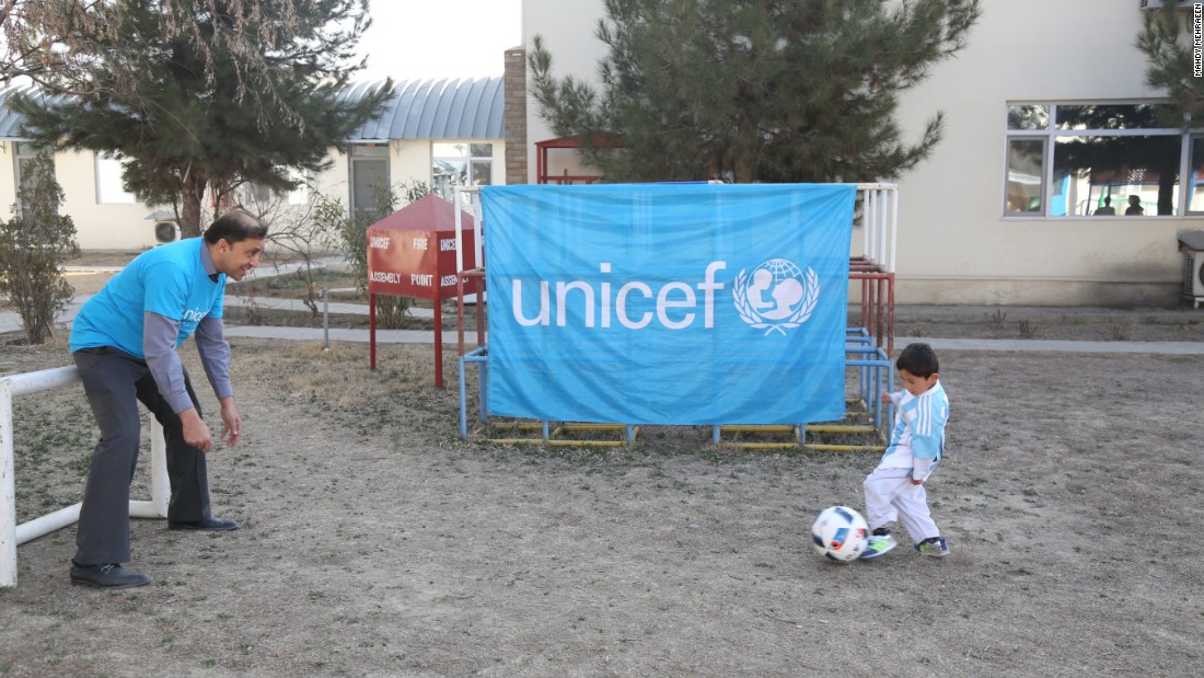 Murtaza dribbles as a UNICEF staffer takes on the role of goalkeeper.