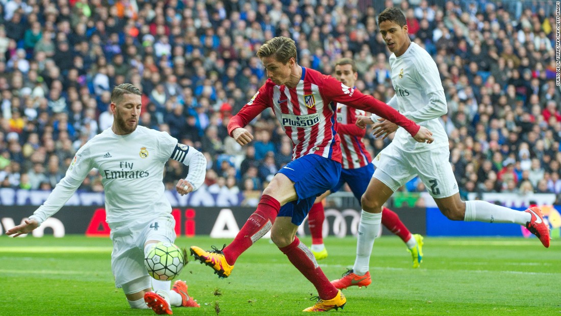 Real Madrid&#39;s defender Sergio Ramos (L) vies with Atletico Madrid forward Fernando Torres.