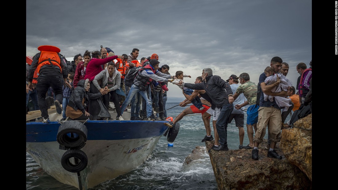 Refugees and migrants get off a fishing boat at the Greek island of Lesbos after crossing the Aegean Sea from Turkey in October 2015.