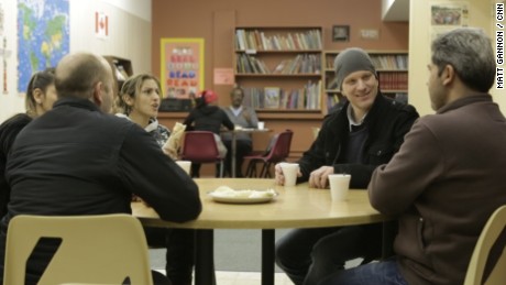 Ryan Dueck, second from right, stops in at a language center for a coffee and conversation with members of the Syrian family his church sponsored.