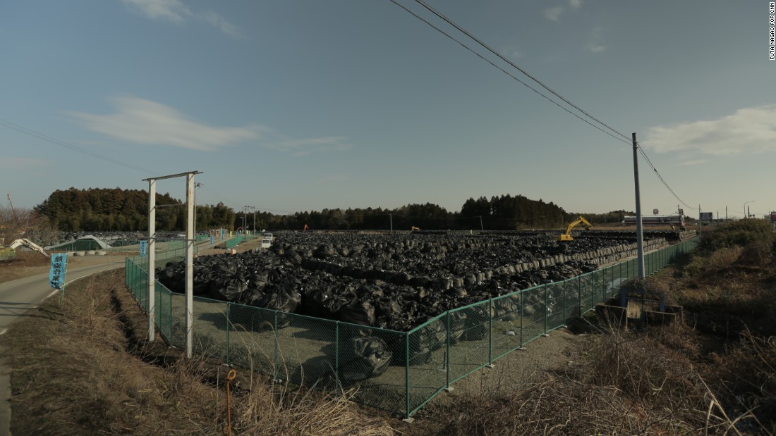 A mountain of black bags filled with contaminated soil sits piled on a roadside in Tomioka, Fukushima. A massive national project to remove topsoil and vegetation contaminated by the Fukushima nuclear disaster will produce at least 22 million square meters of radioactive waste. 