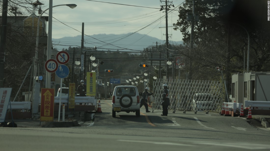 Security guards check passes within the Fukushima exclusion zone, former residents may only visit for up to 5 hours at a time.