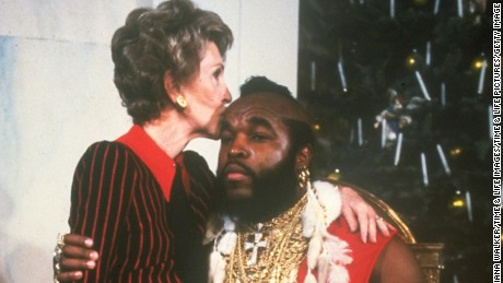 First lady Nancy Reagan sitting on lap &amp; kissing Mr. T done up as Santa Clas at WH Christmas decoration tour.  (Photo by Diana Walker//Time Life Pictures/Getty Images)