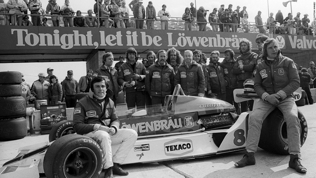 Hunt (right) and French teammate Patrick Tambay (far left) pose with the McLaren M26 car and team at the 1978 United States GP after securing sponsorship from brewer Lowenbrau for the final two races of the season.