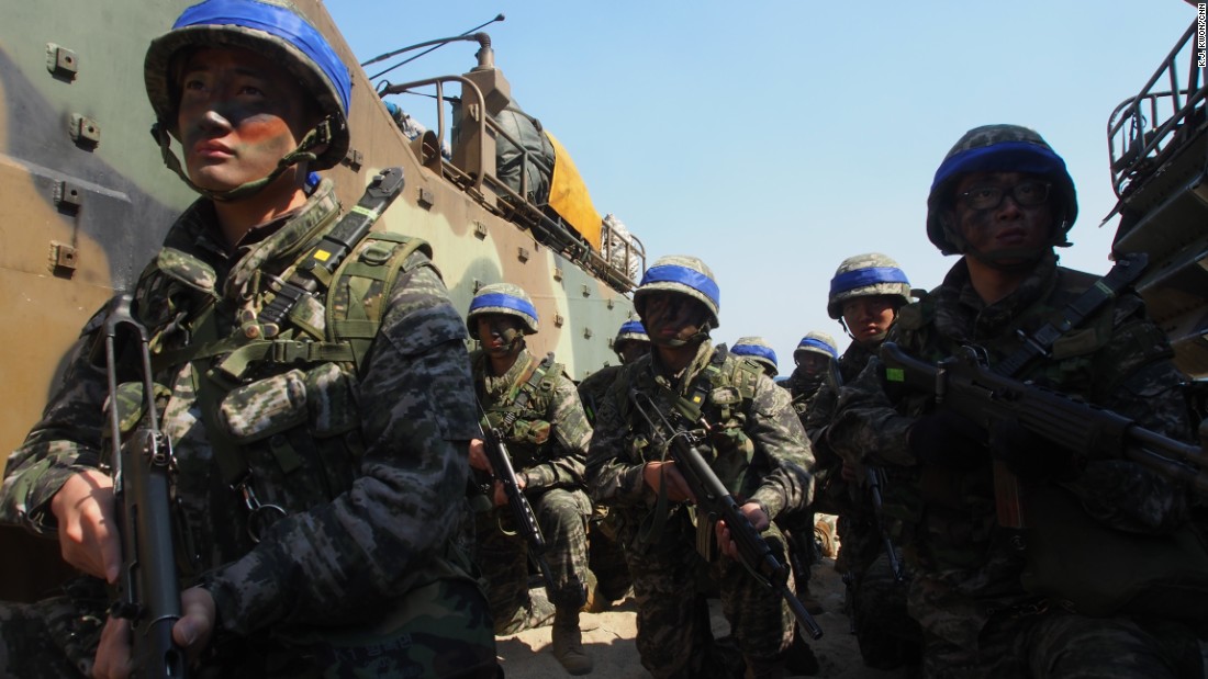 South Korean Marines group crouch between two amphibious assault vehicles during the March 12th drill. 