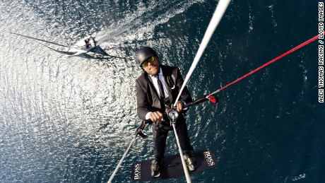 Thomson kite surfs high above his Hugo Boss yacht in a publicity stunt.