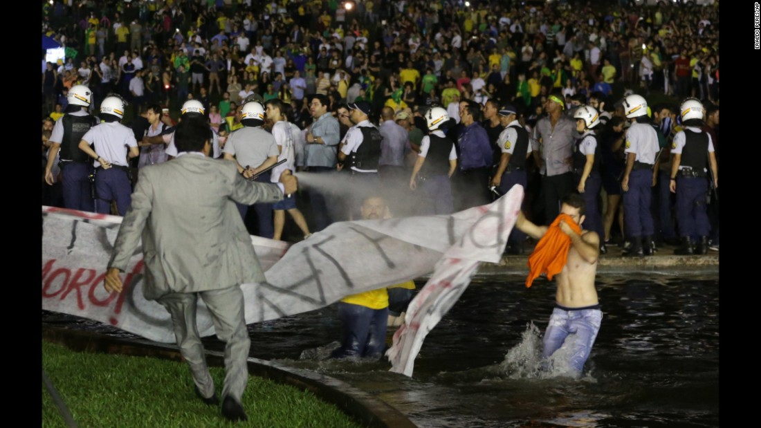 A police officer uses pepper spray on protesters to keep them from getting closer to the Congress building in Brasilia on March 16. 