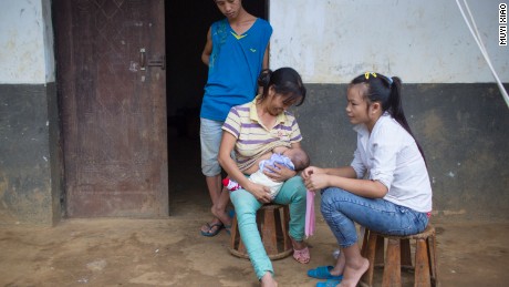 Ming y su mujer, Cai, miran cómo la madre de Mingapos pone la boca de su nieto en su pecho en un intento de calmar al niño. La madre de Mingapos ayuda a la joven pareja cuidando del bebé la mayor parte del tiempo.