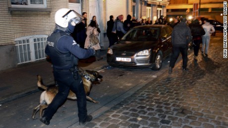 A policeman and a police dog face a crowd  during a police operation in the Molenbeek-Saint-Jean district in Brussels, on March 18, 2016, as part of the investigation into the Paris November attacks.
The main suspect in the jihadist attacks on Paris in November, Salah Abdeslam, was arrested in a raid in Brussels on March 18, French police sources said. / AFP PHOTO / BELGA / DIRK WAEM / Belgium OUTDIRK WAEM/AFP/Getty Images