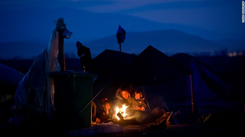 A woman sits with children around a fire at the northern Greek border point of Idomeni in March 2016.