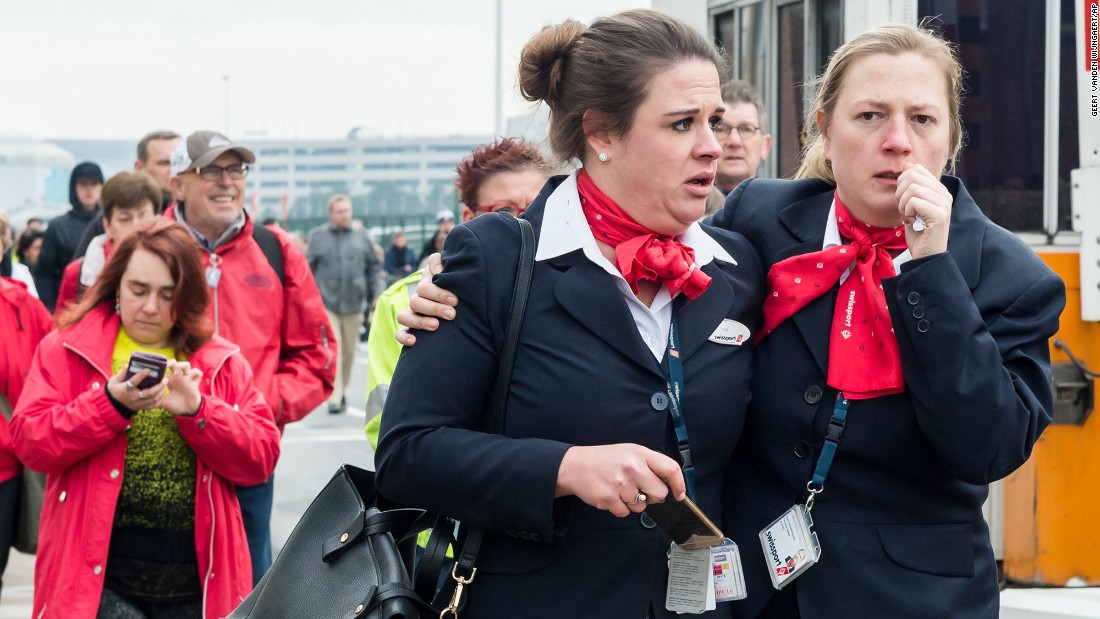 People react as they walk away from the Brussels airport.