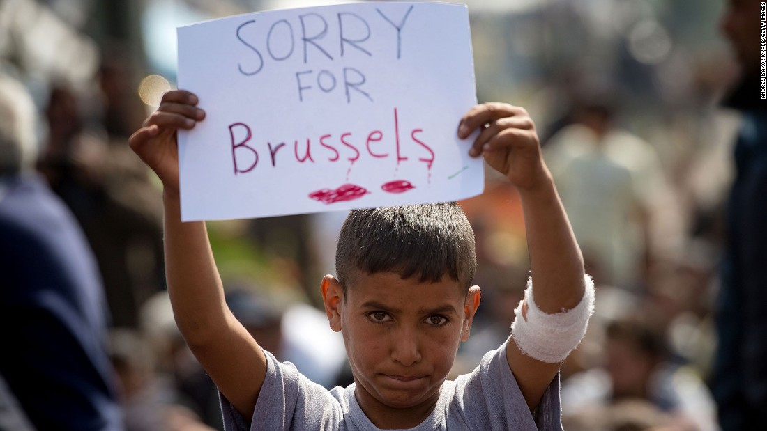 A boy at a makeshift migrant camp shows support for the victims near the village of Idomeni, Greece, on March 22.