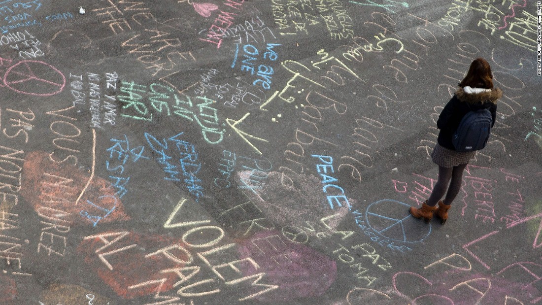 A woman reads messages written on the ground at Brussels&#39; Place de la Bourse on March 22.