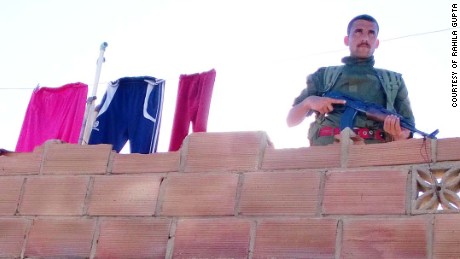 Life in the embattled community: A patrolling soldier stands next to a line of washing.