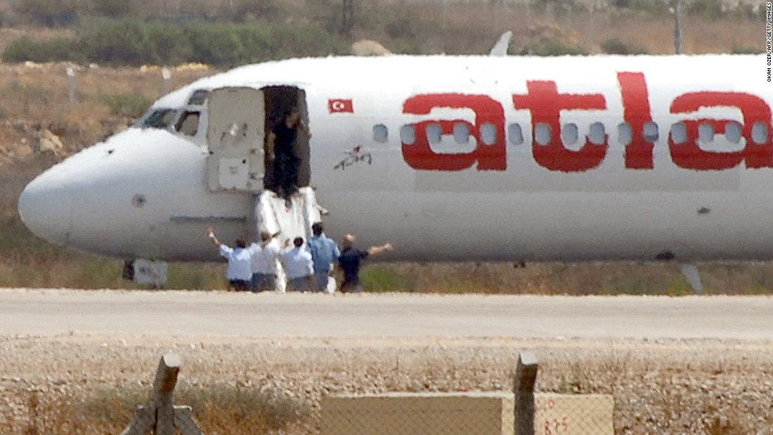 Unidentified men stand by a hijacked Turkish airplane Atlasjet during the surrender of its two hijackers at Antalya Airport in August 2007. The two men who hijacked the Turkish airplane and forced it to land in southern Turkey surrendered, a Turkish official said. 
