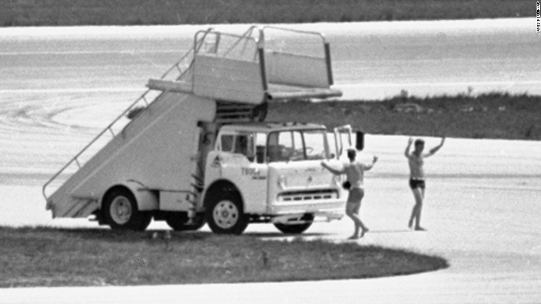 In this July 1972 photo, FBI agents in Miami, wearing only swim trunks, per a hijacker&#39;s instructions, prepare to deliver a case containing a $1 million ransom to a hijacked Delta DC-8 jet.