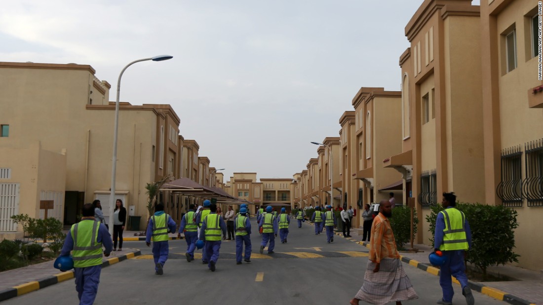 Foreign laborers working on the construction site of the al-Wakrah football stadium, one of Qatar&#39;s World Cup venues, walk back to their accommodation compound after a working day in May 2015.