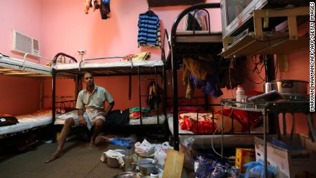 Kupttamon, an Indian laborer working in Qatar, sits in his room at a private camp housing foreign workers in Doha, on May 3, 2015. 