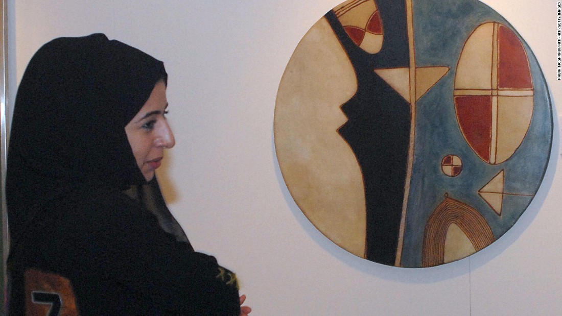 A woman is seen next to an art work by Farid Belkahia of Morocco before Christie&#39;s first public Modern and Contemporary art sale in the Middle East in 2006.