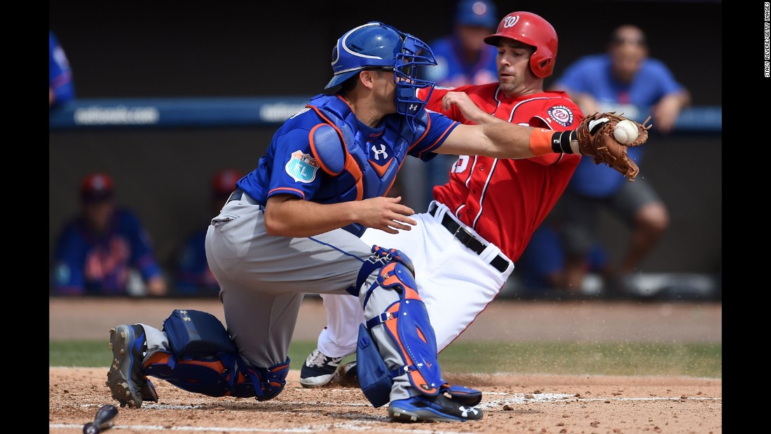 Washington&#39;s Scott Sizemore slides safely into home, beating a tag by New York Mets catcher Travis d&#39;Arnaud during a game in Viera, Florida, on March 11.