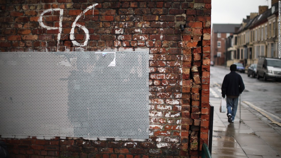 A man walks past &quot;Justice for the 96&quot; graffiti near Anfield soon after the High Court quashed verdicts of accidental death on December 19, 2012. New inquests into the disaster were ordered.