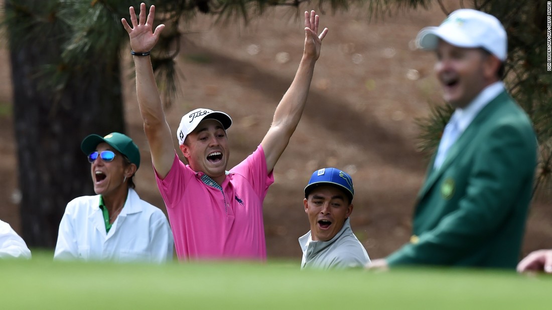 U.S. golfer Justin Thomas (C) celebrates with Rickie Fowler after shooting a hole-in-one at the fourth... 