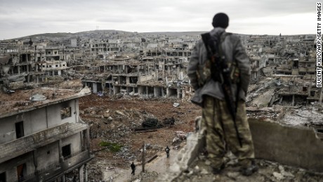 A Kurdish marksman stands atop a building as he looks at the destroyed Syrian town of Kobani on January 30, 2015. Kurdish forces recaptured the town on the Turkish frontier on January 26, in a symbolic blow to the jihadists who have seized large swathes of territory in their onslaught across Syria and Iraq.