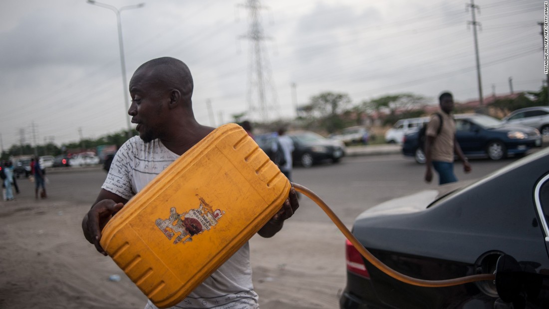 Due to the fuel shortage, there has been increased activity of black market hawkers selling gas at inflated prices. Pictured, a hawker fills a car with fuel on the side of the road in Lagos on April 6, 2016.