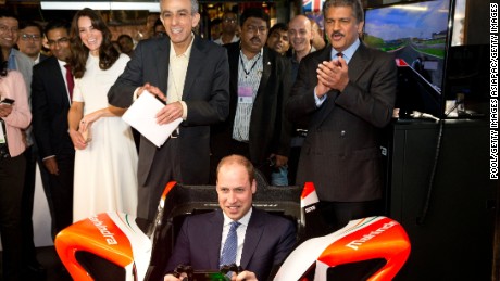 Prince William flies in a Formula E simulator in India, watched by his wife Catherine, Duchess of Cambridge.