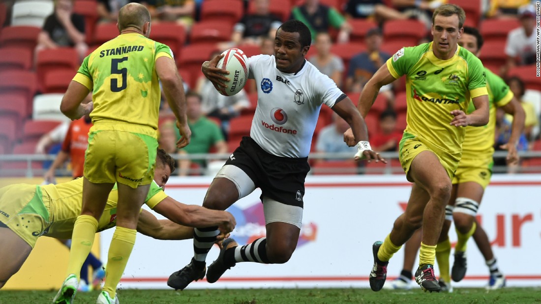 Fiji&#39;s Kitione Taliga (C) runs past Australian players during their Cup quarter-final match at the Singapore Sevens rugby tournament on April 17, 2016. 