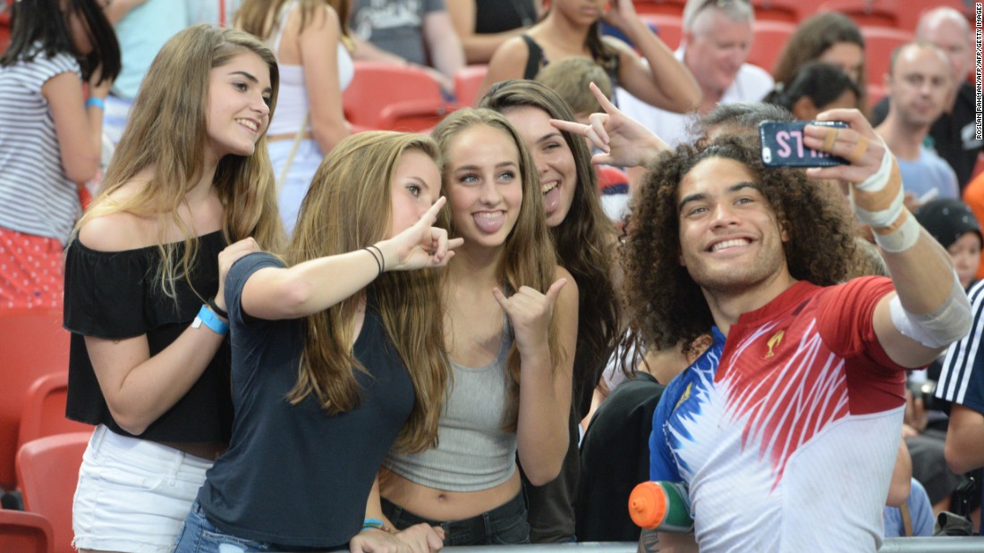 France&#39;s Pierre Gilles Lakafia (R) takes a selfie with fans during the Singapore Sevens rugby tournament on April 17, 2016. 