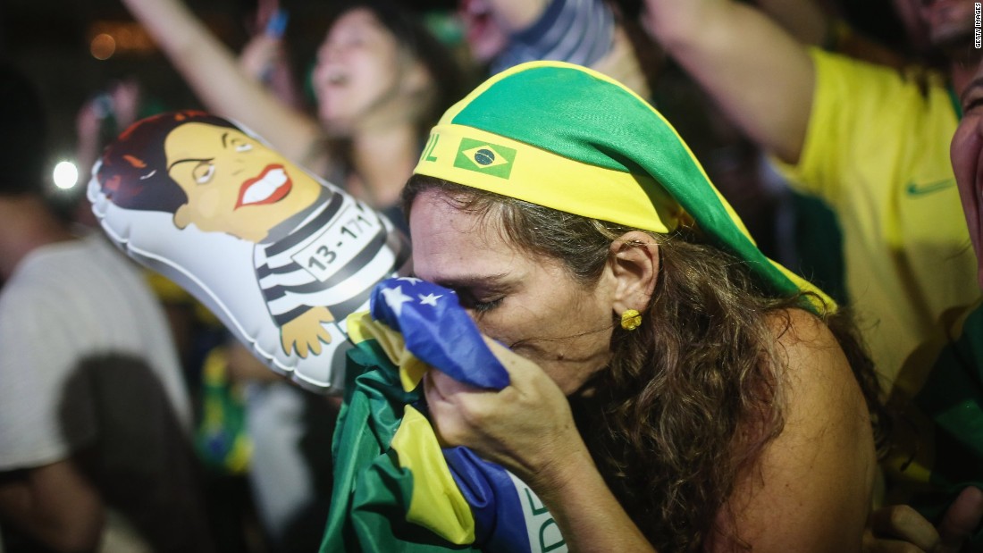 A pro-impeachment supporter kisses a Brazilian flag while watching a live television broadcast moments after lower house deputies vote to approve the motion to continue the impeachment process.