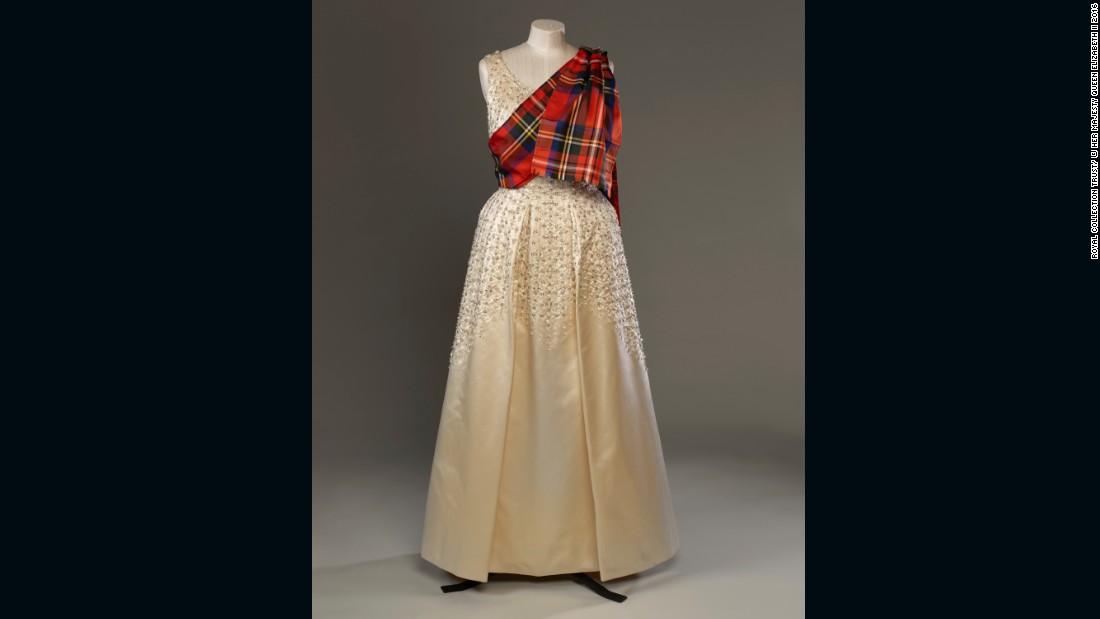 Evening dress by Norman Hartnell with a sash of Royal Stewart tartan, worn to the Gillies Ball at Balmoral Castle.