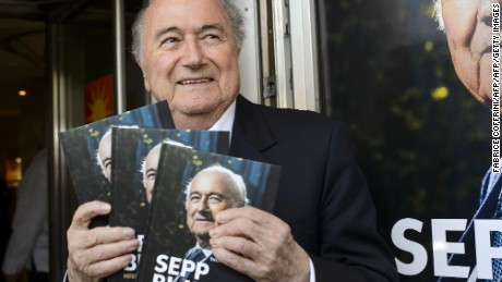 FIFA&#39;s ex-president Sepp Blatter poses with a copy of his biography.