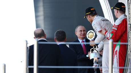 Rosberg is handed his winner&#39;s trophy by Russia president Vladimir Putin