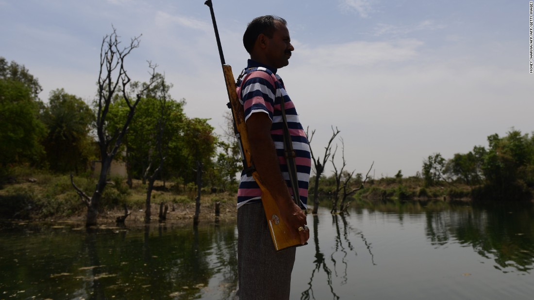 A gunman stands guard at a water reservoir in the central Indian state of Madhya Pradesh on Wednesday, April 27, 2016.