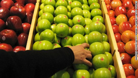 BEIJING - JANUARY 27:  A shopper chooses granny smith apples at the newly-opened Tesco supermarket on January 27, 2007 in Beijing, China. The UK giant opened its first own-brand supermarket in Beijing after investing in 46 stores across China under the name of its Chinese partner, Le Gou, which translates as &quot;Happy Shopping&quot;. Tesco&#39;s new store in Beijing is competing with other international chains that are well established in China, such as Wal-Mart and Carrefour.  (Photo by Andrew Wong/Getty Images)