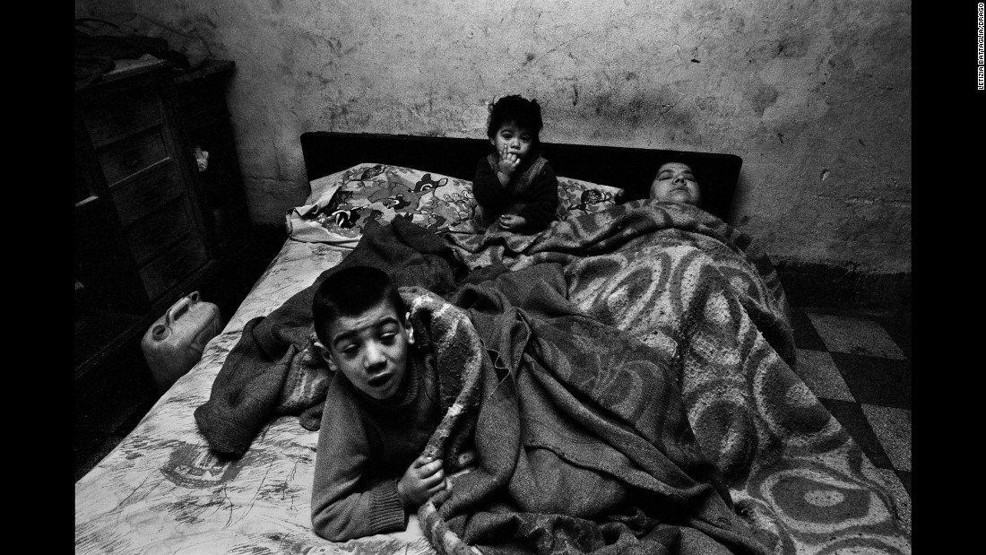 A woman and her children are photographed in Palermo in 1978. &quot;I was shooting poor people, and I entered a house around noon,&quot; Battaglia said. &quot;I asked her, &#39;Why are you in bed at this hour?&#39; and she said, &#39;I have no fire, no light, no food ... what can I do?&#39; People brought her spaghetti, but she was always in bed with the children. I always wondered what happened to this woman and those children.&quot;