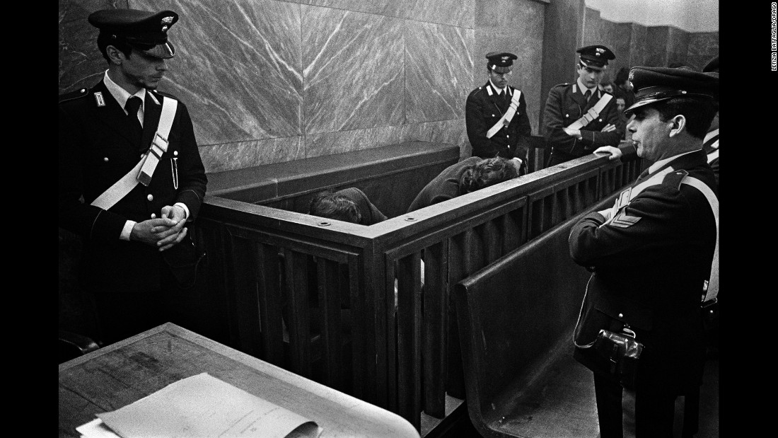 Men accused of organized crime hide from cameras at a trial in Milan, Italy, in 1971.