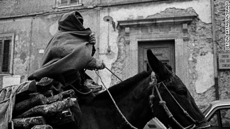 A man covers himself with a cloak in the streets of Sicily in 1989.