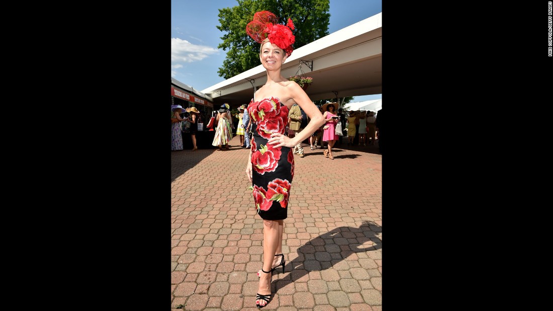 A fan wears a floral themed dress and matching hat. 