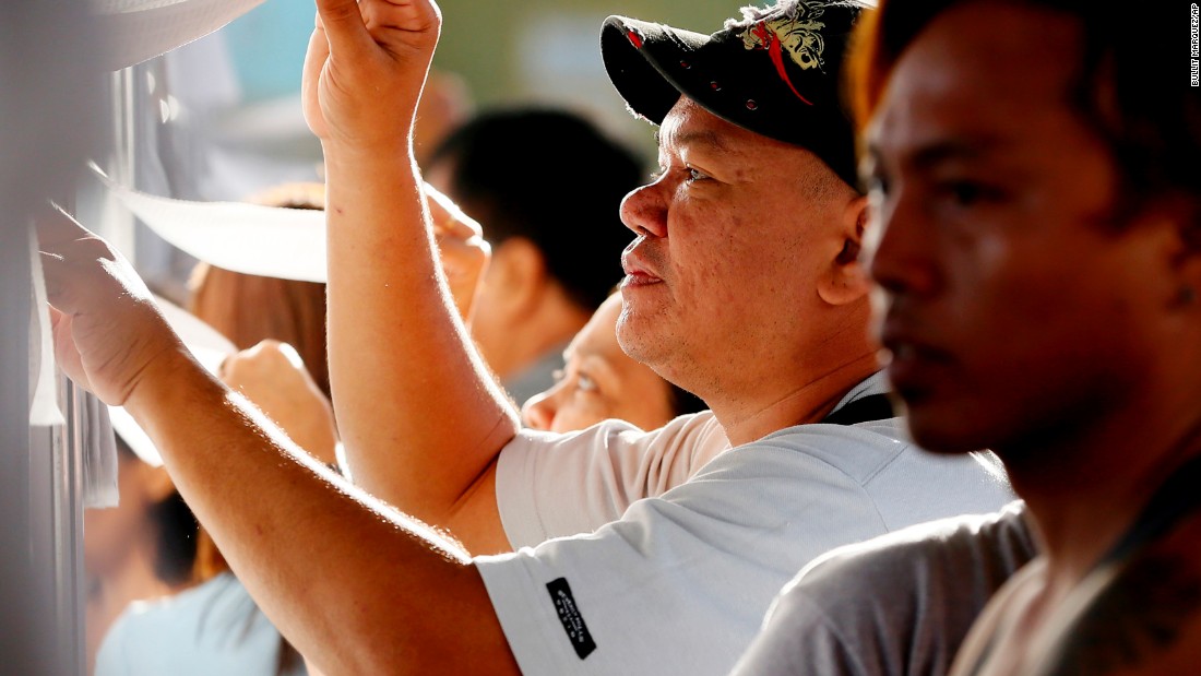 Filipino voters check the voters&#39; list as they queue up to cast their choice for the presidential elections in Davao City in southern Philippines on May 9, 2016. 