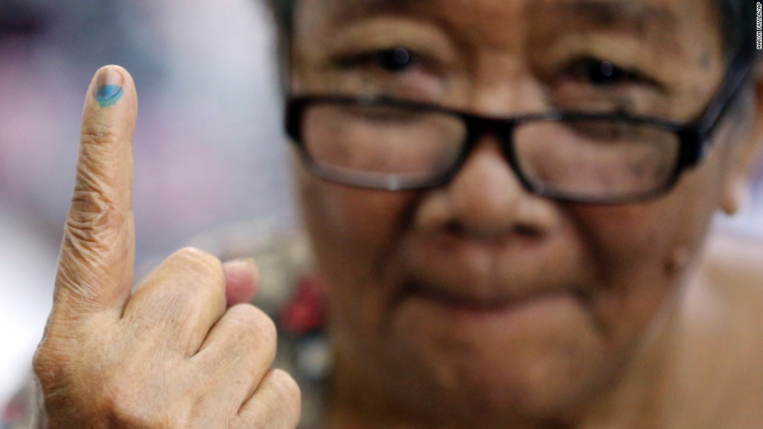 Esteban shows the indelible ink on her finger after casting her vote.