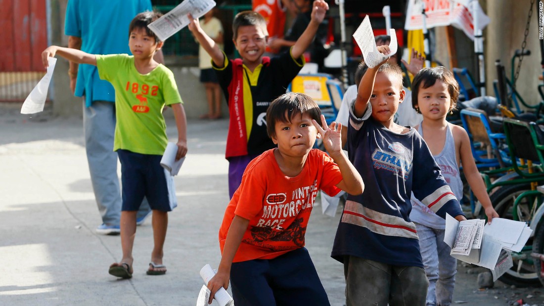 Boys distribute election leaflets outside a polling precinct in Davao City on May 9, 2016. 