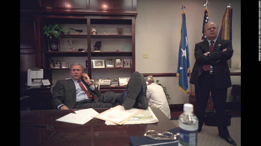 Bush talks on the phone at a Louisiana Air Force base as adviser Karl Rove stands by.