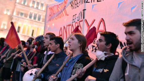 Young people shout slogans in front of the Greek parliament building in Athens on May 8, 2016. 