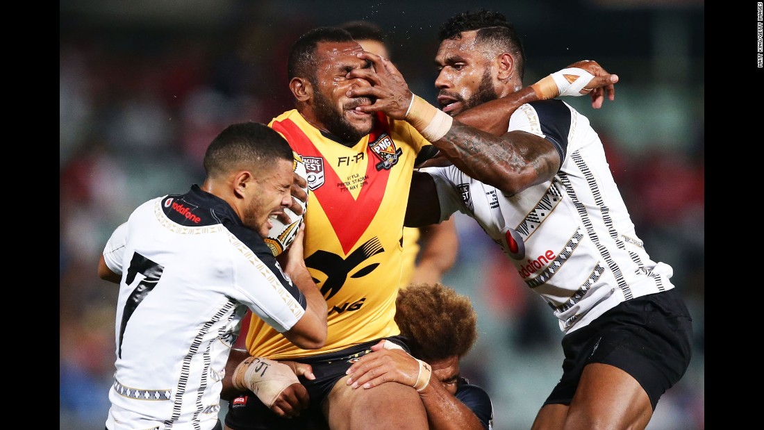 Edward Goma, a rugby player from Papua New Guinea, is tackled by Fiji players during a match in Sydney on Saturday, May 7.
